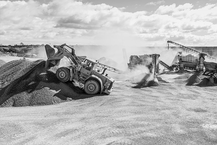 Trucks in tough terrain with buckets and bodies in Hardox® steel, loading abrasive materials.