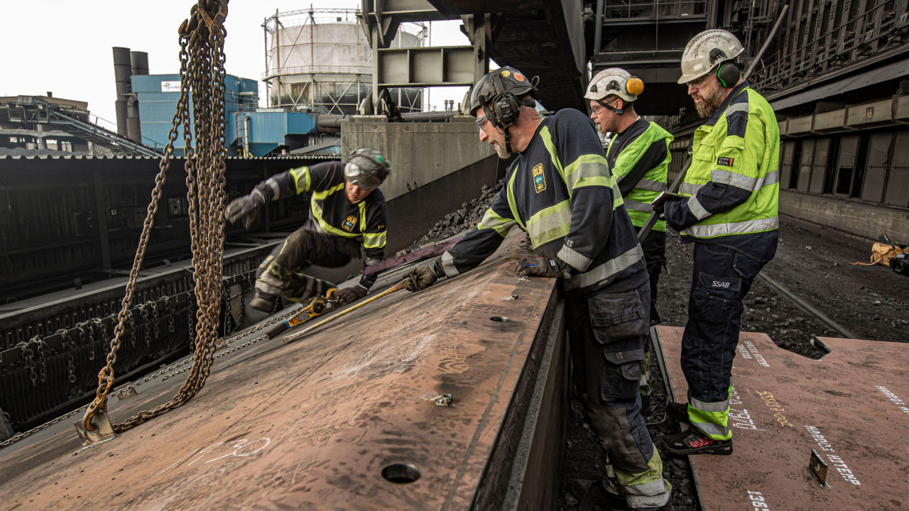 Рабочие в касках проверяют сдвижную платформу из стали Hardox® HiTemp на сталелитейном заводе в городе Укселёсунд, Швеция.