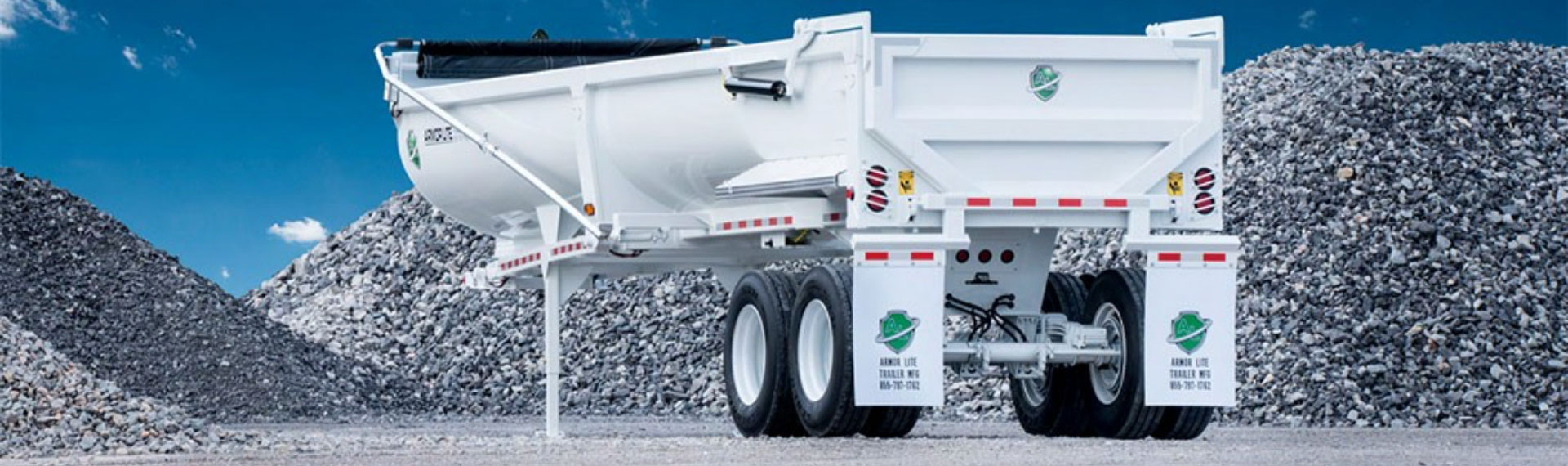 A white half-round dump trailer in steel bearing the Hardox In My Body logo.