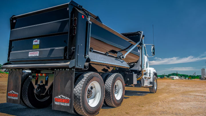 Một chiếc xe tải tự đổ màu đen có thùng rơ-moóc được làm bằng thép Hardox® 500 Tuf.   