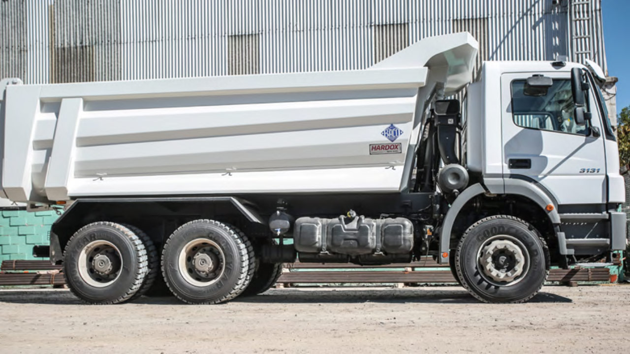 Un camion ribaltabile bianco in Hardox 500 Tuf con pannello laterale conico