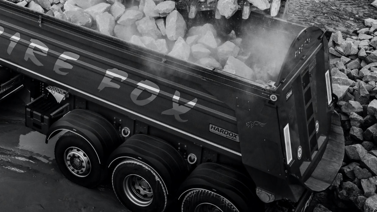Hình ảnh đen trắng của thùng xe tự đổ Firefox chở đầy đá, được làm bằng thép tấm chịu mài mòn Hardox® 500 Tuf.