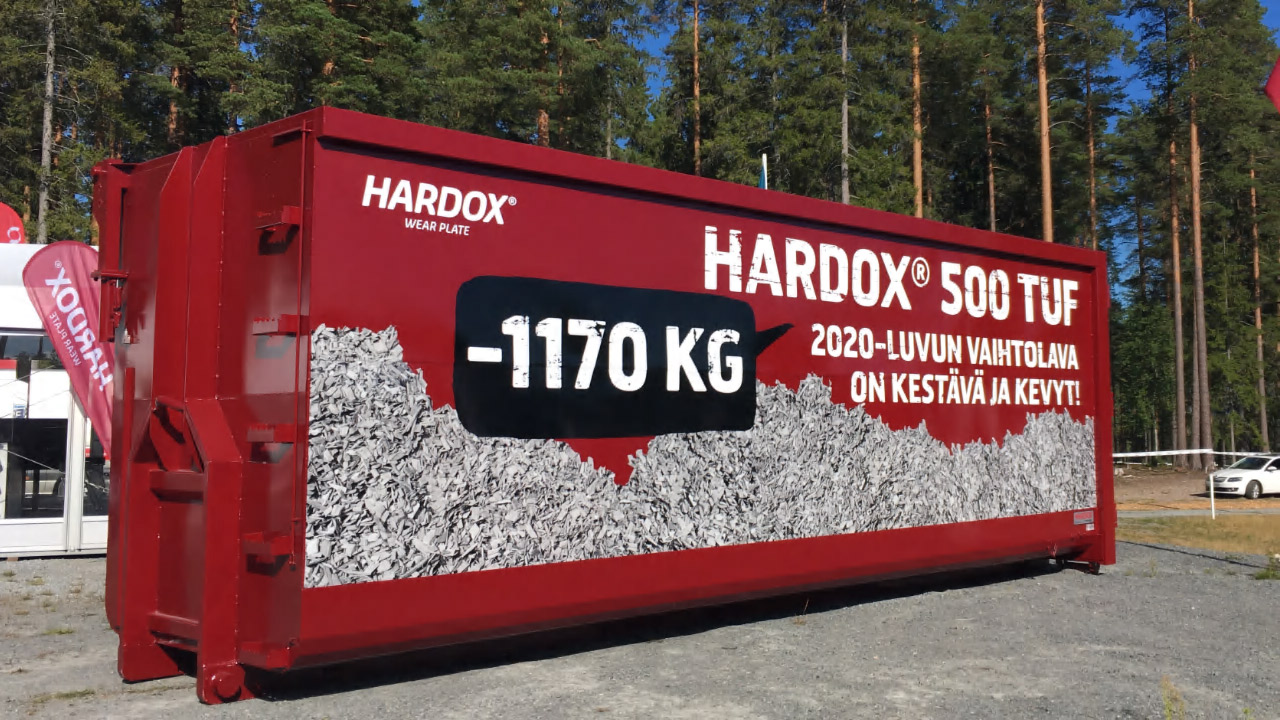 森林に置かれたHardox 500 Tuf鋼板製の鮮やかな赤色のスティールコンテナ。