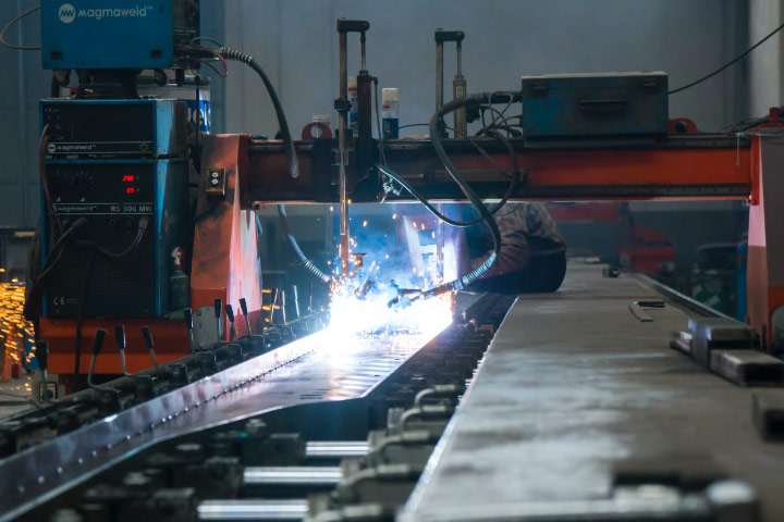 A welder in a workshop, welding a thin yet strong sheet of Hardox® wear plate.