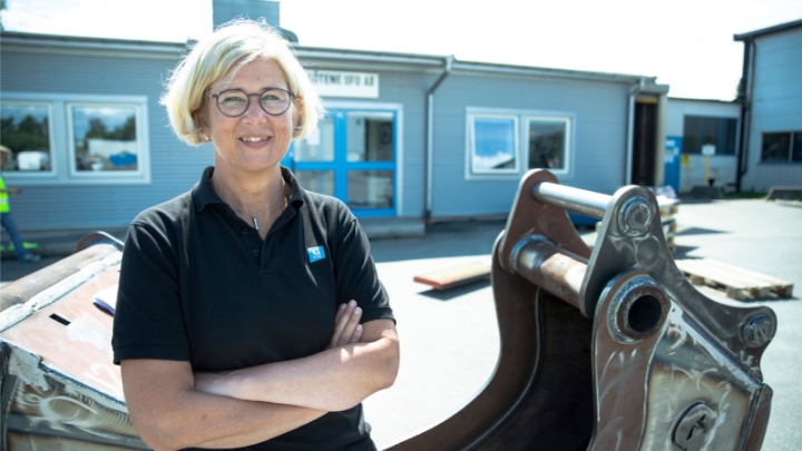 Photo de Birgitta Boström, PDG de Götene Ufo, à côté d’un godet d’excavatrice.