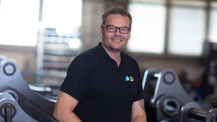 Photo of Götene Ufo’s site manager Marco Lundahl in front of buckets made with Hardox® wear steel.