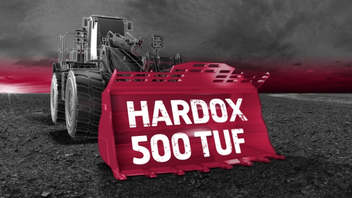 Trwała i mocna stal Hardox® 500 Tuf w łyżce ładowarki kołowej na tle szarego nieba.