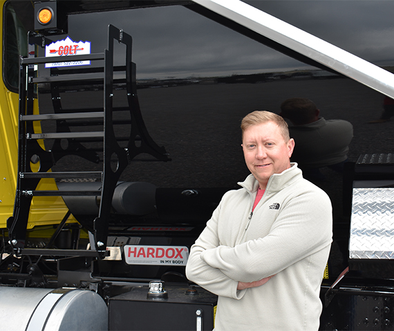 Giám đốc điều hành Industrial Welding Supply đang đứng trước thùng xe tải tùy chỉnh mang nhãn hiệu Colt và được chứng nhận Hardox® My Body.