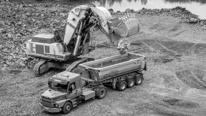 Máy đào đang chất đất đá lên một thùng xe tải được làm bằng thép Hardox® 450 chắc khỏe và dẻo dai