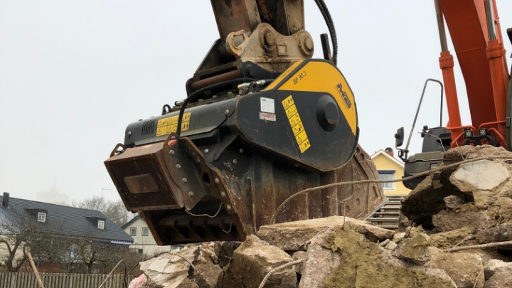 Excavator with an MB BF90.3 crusher bucket is crushing concrete with rebar.