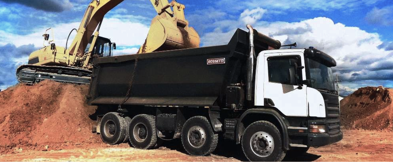 A black dump truck body made in Hardox® 500 Tuf steel being loaded with abrasive rocks. 