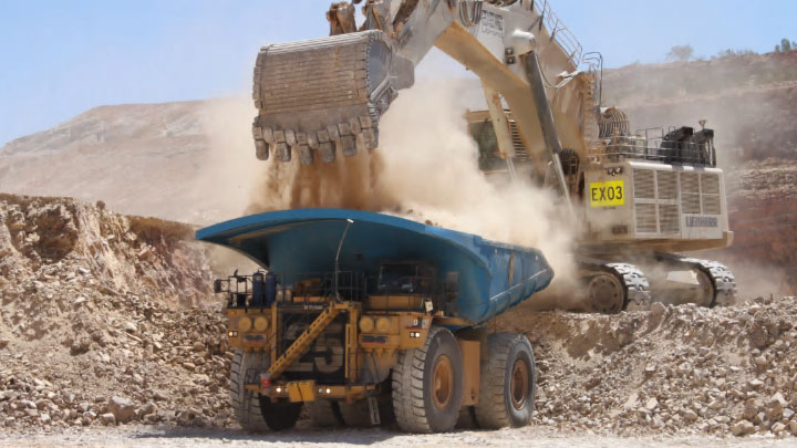 Caminhão de mineração a céu aberto em ação carregando rochas