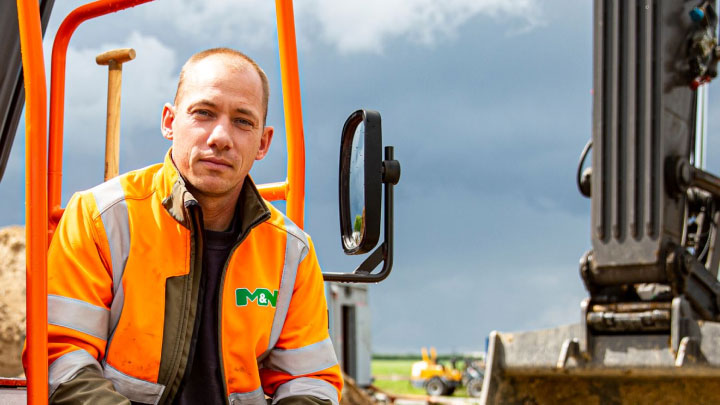 Ein Maschinenbediener sitzt auf einem Volvo Hybridbagger mit einer Schaufel aus besonders zähem Hardox® 500 Tuf.