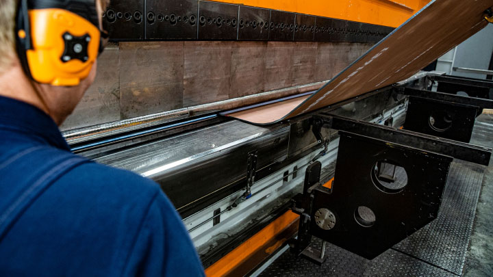 A metal fabricator bending a piece of Hardox® 500 Tuf plate.