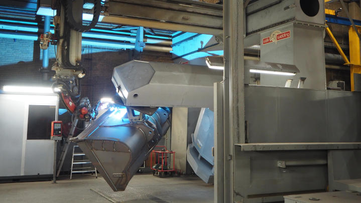 A custom excavator bucket being built using robotic welding