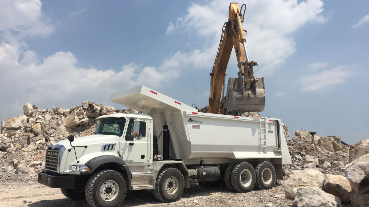 Rocks being loaded into a strong and tough dump truck on a mining site.