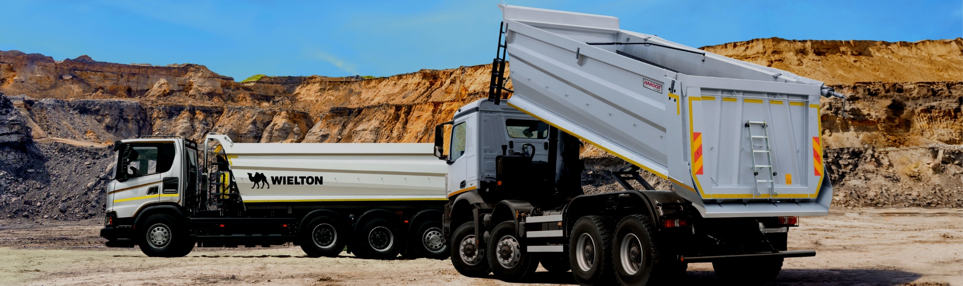 Two tipper trucks from Wielton in a mine, with the Hardox® In My Body sign on the bodies.