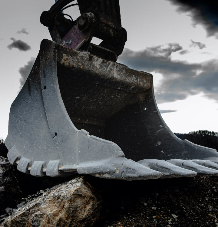 A gigantic heavy-duty bucket posing against a stormy sky