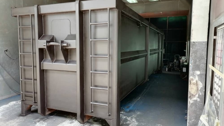Một thùng chứa rác thải màu xám có đuôi xe và cửa xe được làm bằng thép Hardox® HiAce, một loại thép chống ăn mòn. 