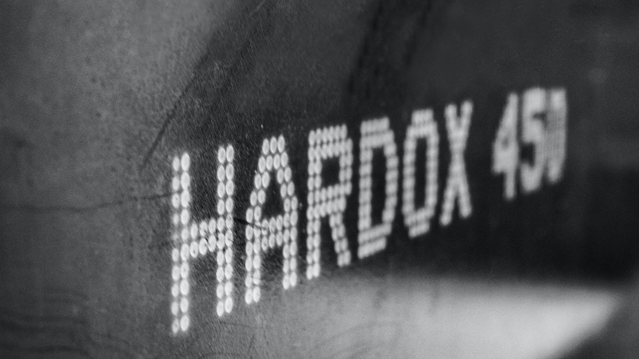 Cận cảnh thương hiệu thép Hardox® 450 trên một tấm thép chịu mài mòn.