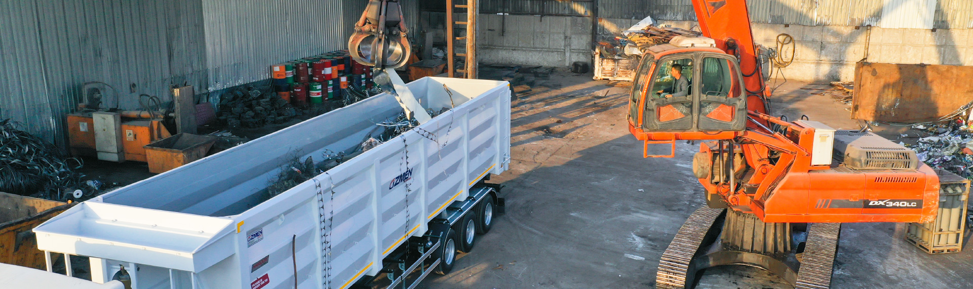 Hero image: An orange crane loading scrap into a box-type tipper made in Hardox® 500 Tuf steel.