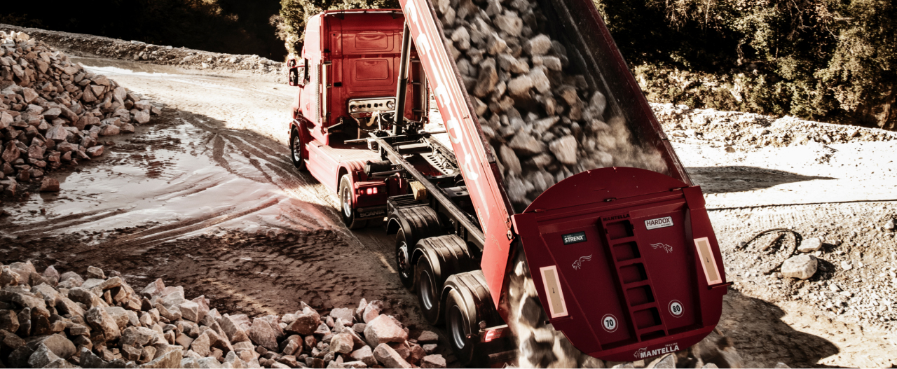 Red dump body made in Hardox® 500 Tuf steel dumping out some abrasive rocks.