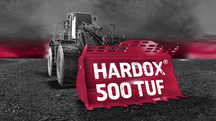 A heavy-duty loader bucket made in extra-tough Hardox® 500 Tuf, scooping up the Hardox® 500 Tuf logo.