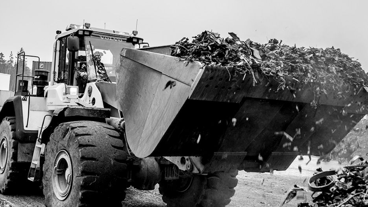 A truck about to dump a load of corrosive waste from its bucket.