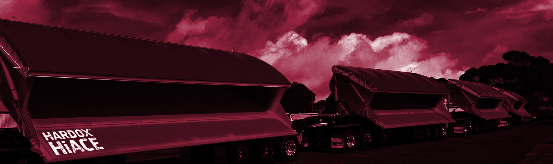 Hardox HiAce 내부식성 강재 제품 페이지. 덤프 트럭이 불타오르는 붉은 하늘을 배경으로 산성 부식성 폐기물을 덤핑하고 있습니다.