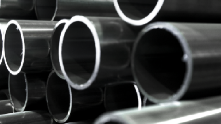 A stack of Hardox tubes and pipes photographed at an angle