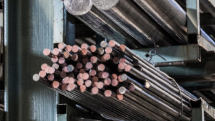 Barras metálicas Hardox em uma oficina, prontas para processamento.