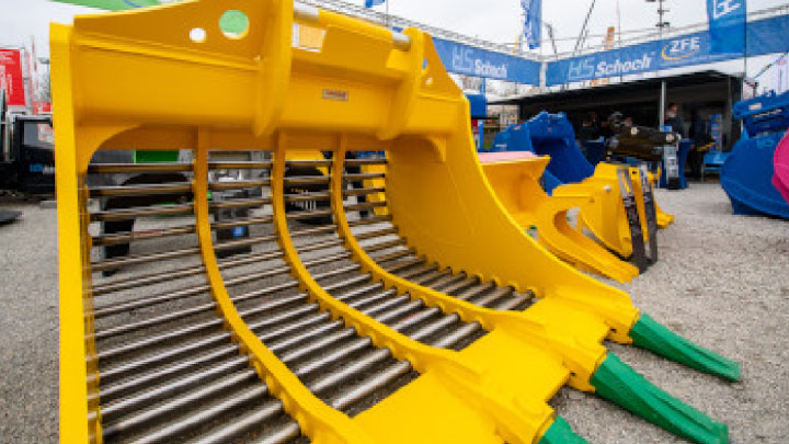 A yellow skeleton bucket by HS Schoch, who uses Hardox® round bars to get longer, more reliable service.