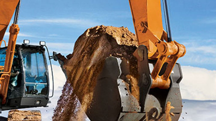 A heavy-duty bucket attachment made in Hardox® wear steel, against a blue sky.