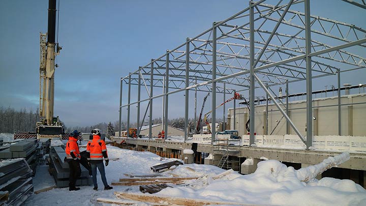 Two men standing beside a building construction site