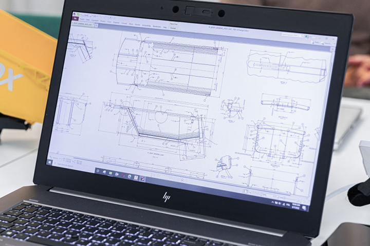 Un laptop che mostra i disegni della carrozzeria di un rimorchio in acciaio.