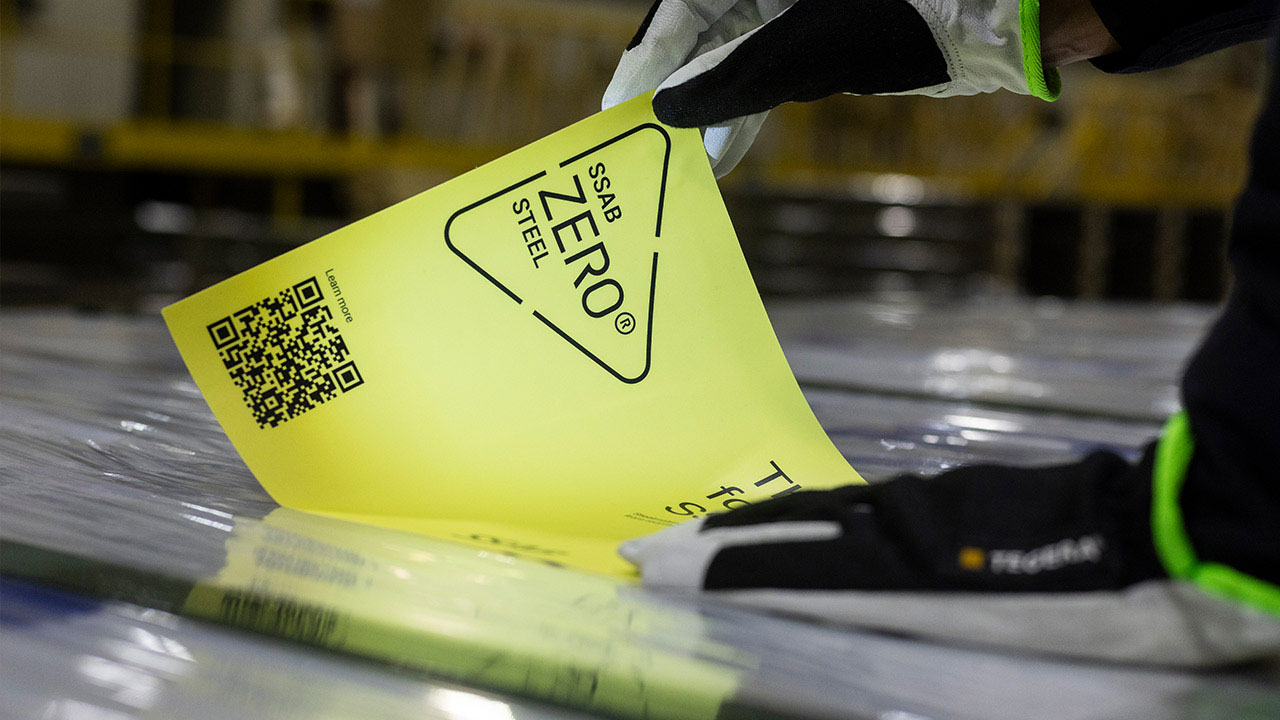 Bild av en person som sätter en SSAB Zero® etikett på ett paket med stål
