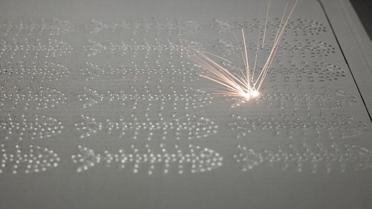 A laser beam burning into a layer of steel powder to create 3D objects