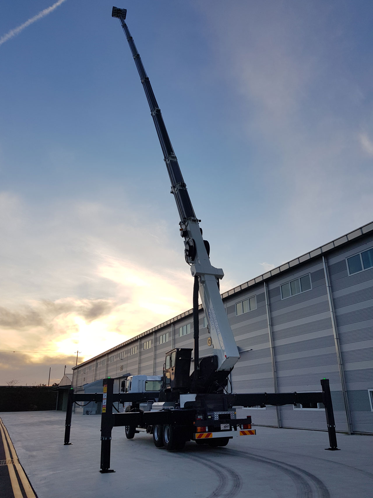 Huge spider lift reaching up to the sky at sunset, with strong yet light boom made in Strenx® 960 Plus steel.
