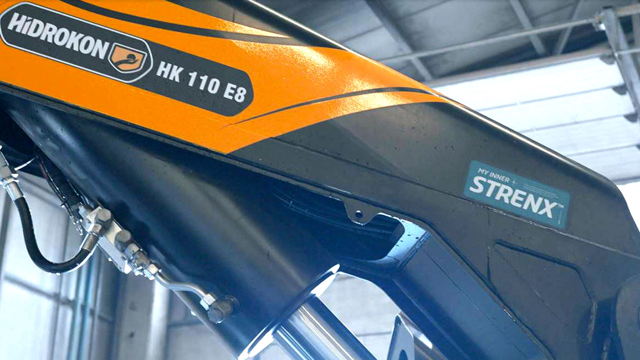 Крупным планом стрела гидравлического крана с логотипом «My Inner Strenx», который свидетельствует о том, что производитель сертифицирован на соответствие высоким стандартам качества и использует оригинальную сталь Strenx®.