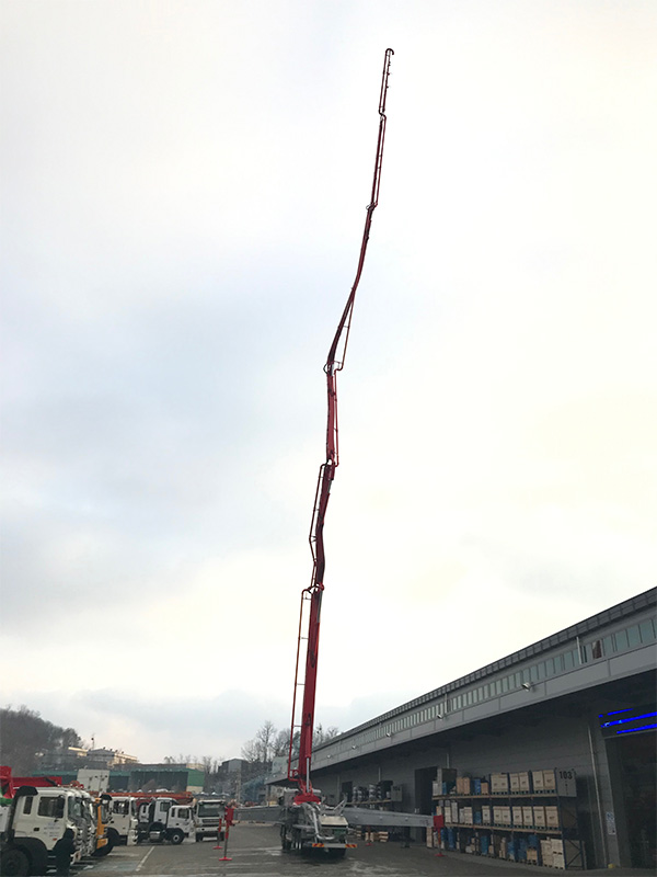 Niesamowicie długi, ale mocny wysięgnik pompy do betonu wykonany ze stali Strenx 1100, sięgający nieba. Niesamowicie długi, ale mocny wysięgnik pompy do betonu wykonany ze stali Strenx 1100, sięgający nieba.