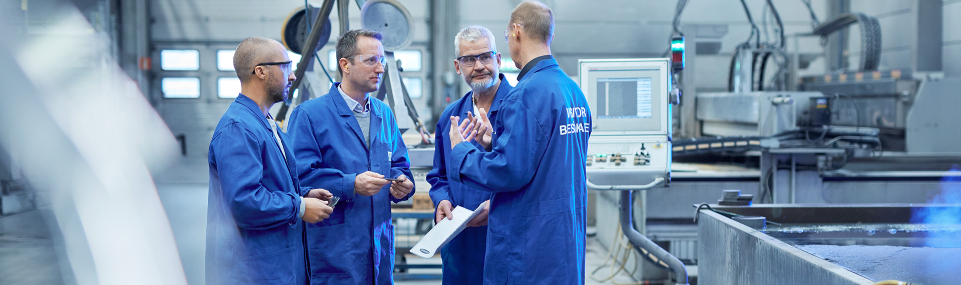 Gruppo di persone che discutono della produzione dei componenti delle macchine